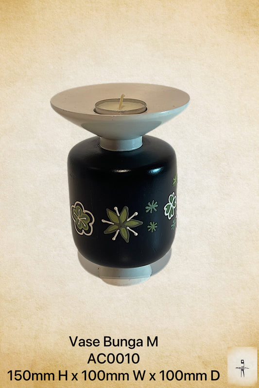 A black vase with a white lid, featuring a green floral pattern and stars design, used as a candle holder.