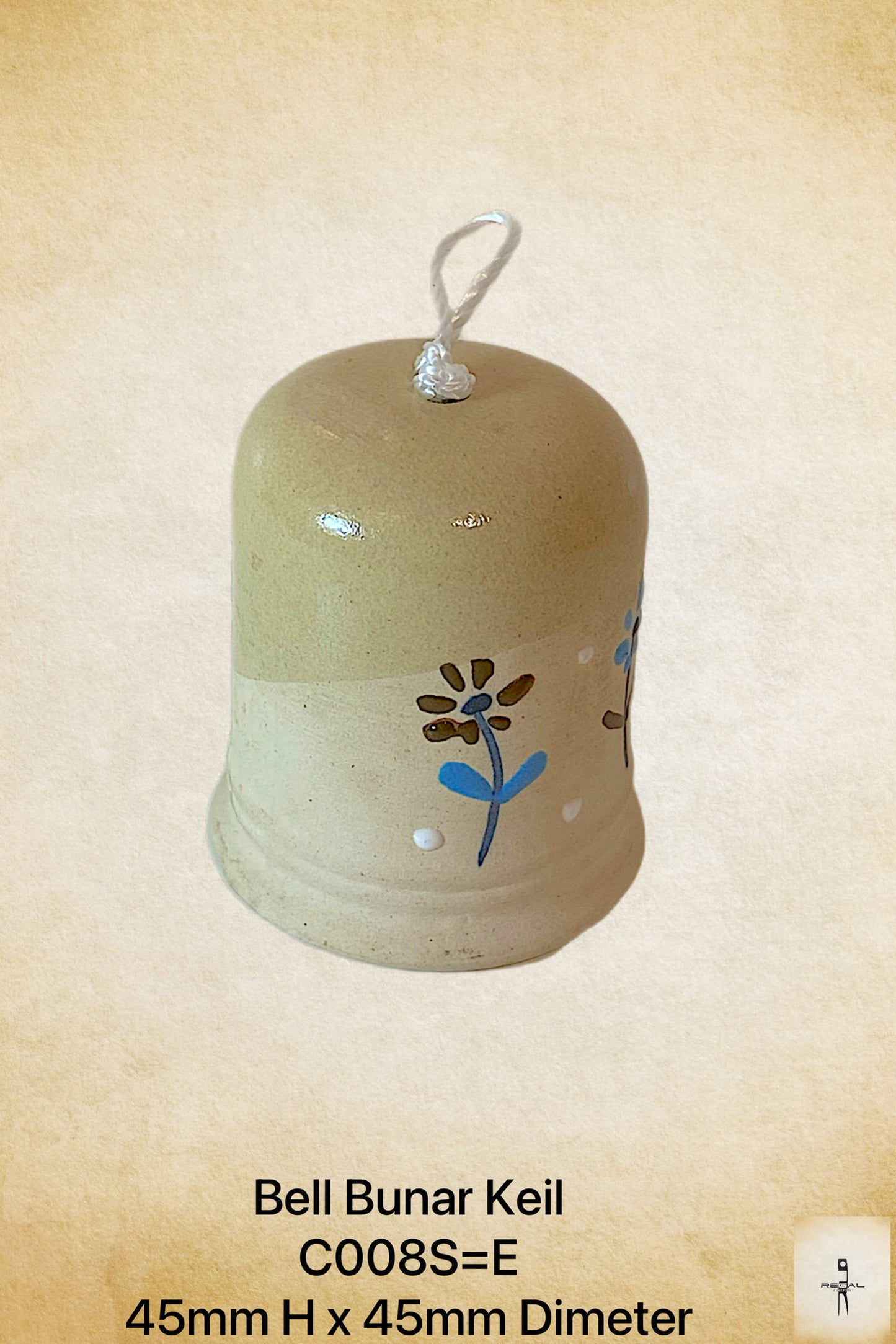 A beige ceramic decorative bell with a floral pattern and a white line drawing on it, displayed against a textured background.