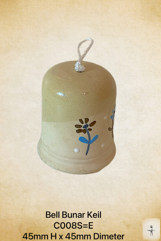 A beige ceramic decorative bell with a floral pattern and a white line drawing on it, displayed against a textured background.