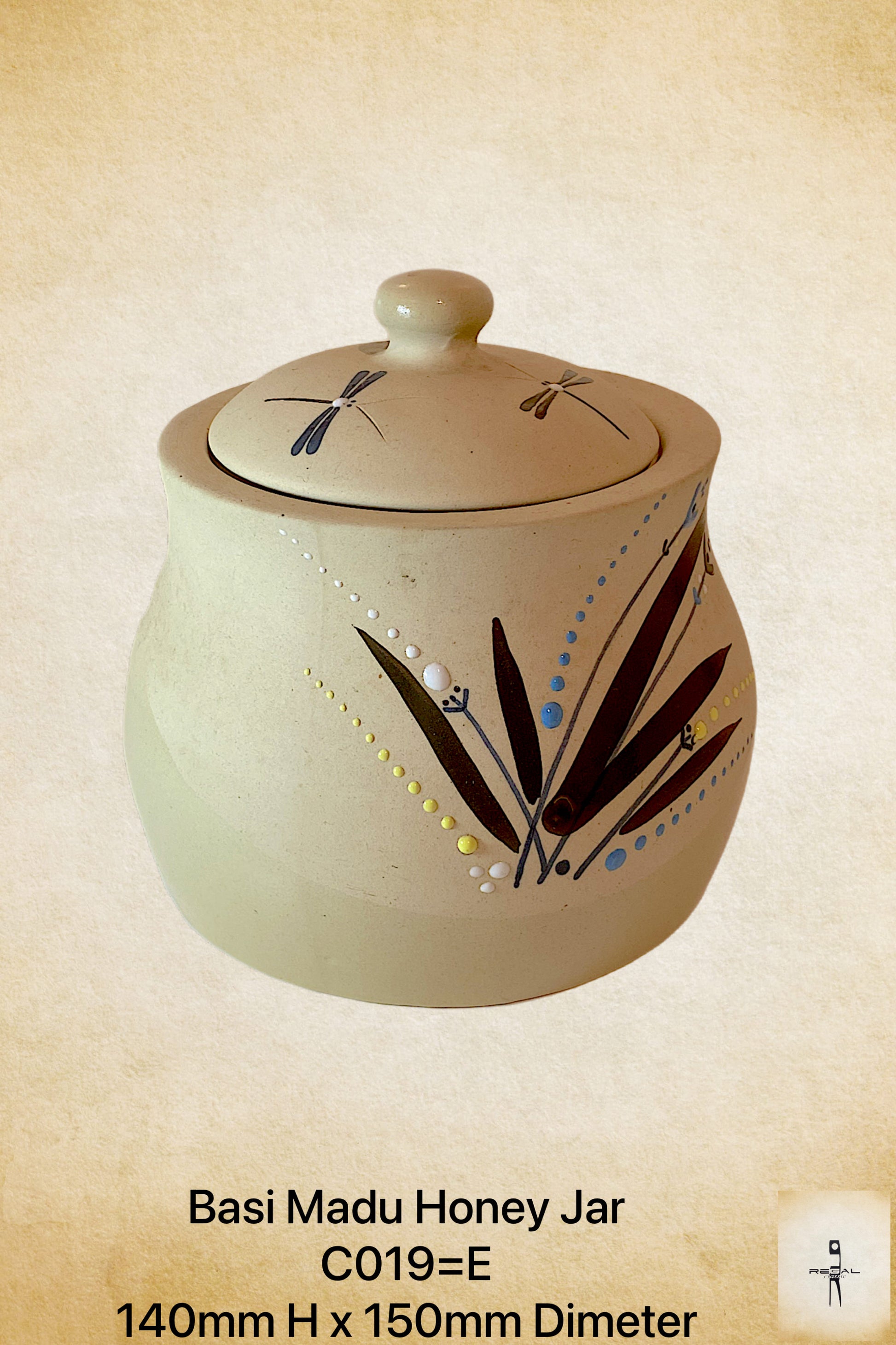 A beige ceramic honey jar with a lid, featuring blue and yellow floral patterns and dragonfly motifs.
